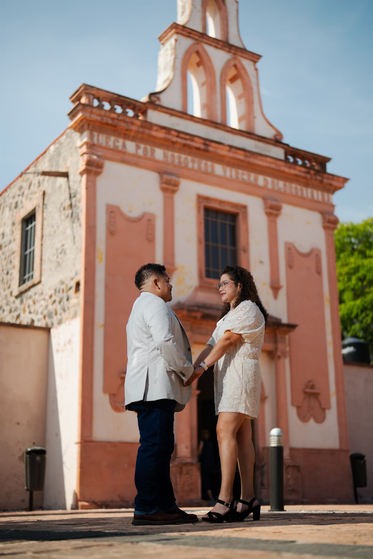 Silvia y Omar frente a una iglesia durante una sesión de pareja